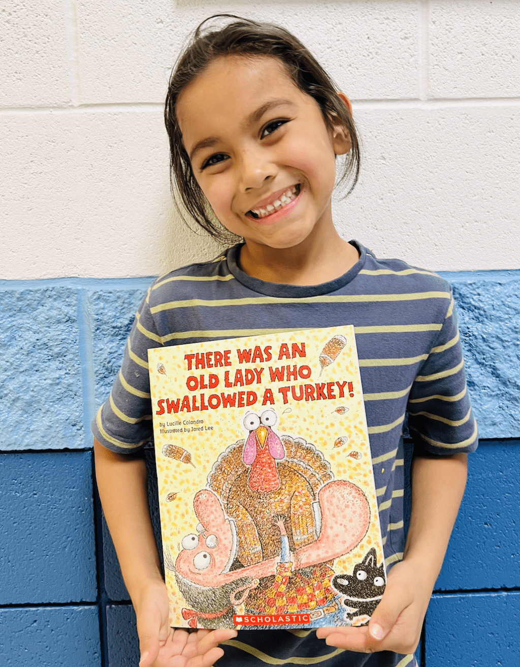 student holding a book received for earning a  praise award